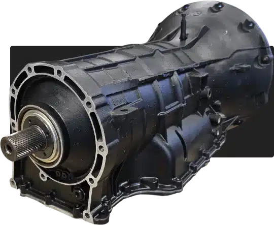 1023 Diesel & Fleet: Close-up of a black automotive transmission, showcasing its intricate metal casing and cylindrical components with a visible output shaft on the left. The design features several bolts and structural ridges.