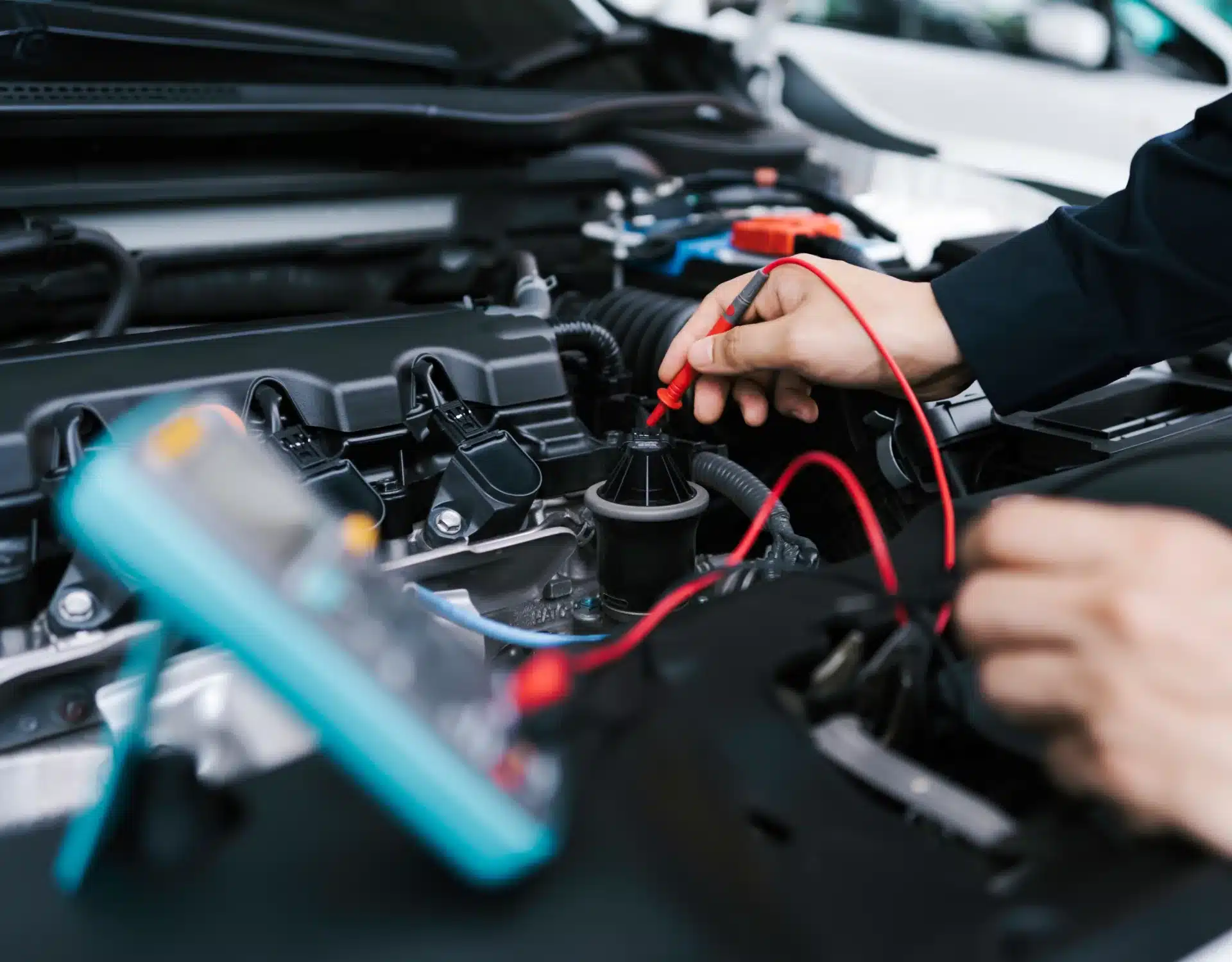 1023 Diesel & Fleet: A person using a multimeter to test the engine of a car, with red and black test leads connected to various components. The car hood is open, revealing detailed engine parts.