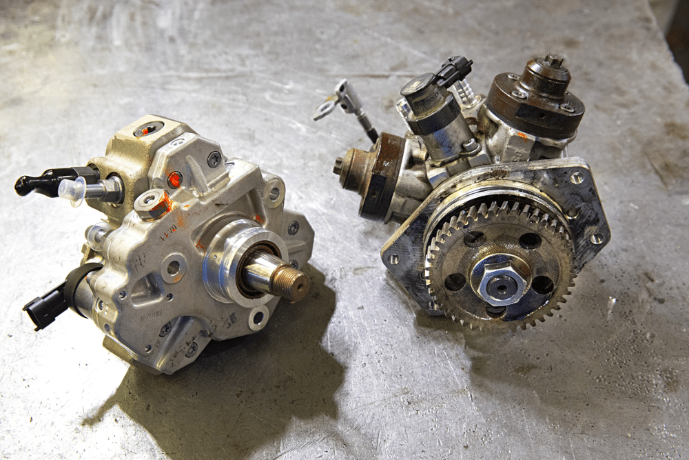 CP3 conversion, diesel repair in Palmer, AK at 1023 Diesel & Fleet. Side-by-side comparison of a new CP3 fuel pump and an older pump on a workbench, highlighting components used in Duramax CP3 conversion.