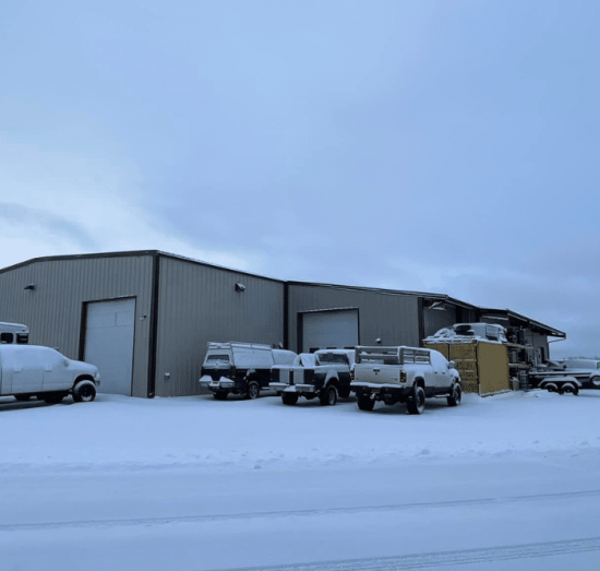 cold weather diesel, diesel repair in Palmer, AK at 1023 Diesel & Fleet. Snow-covered trucks outside auto repair shop in winter conditions.